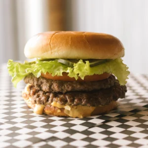 a hamburger on a black and white checkered surface