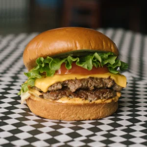 a cheeseburger on a black and white checkered surface