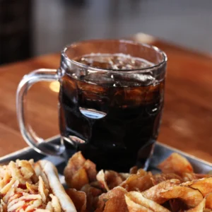 a glass of coke and chips on a tray