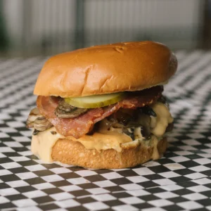 a meltdown burger on a black and white checkered surface