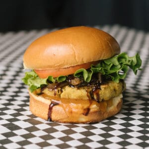 a reformer burger on a black and white checkered surface