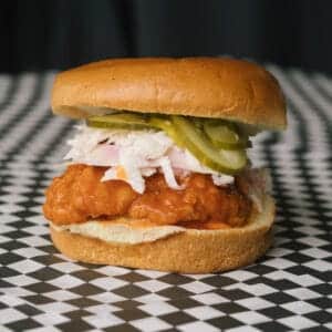 a spicy chicken sandwich on a black and white checkered surface