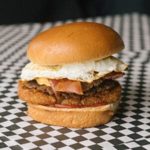 an uprising burger on a black and white checkered surface