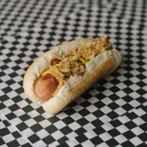 a traitor hot dog on a black and white checkered surface