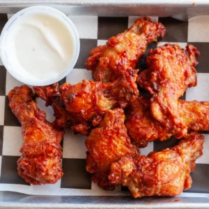 closeup of wings with a cup of dip