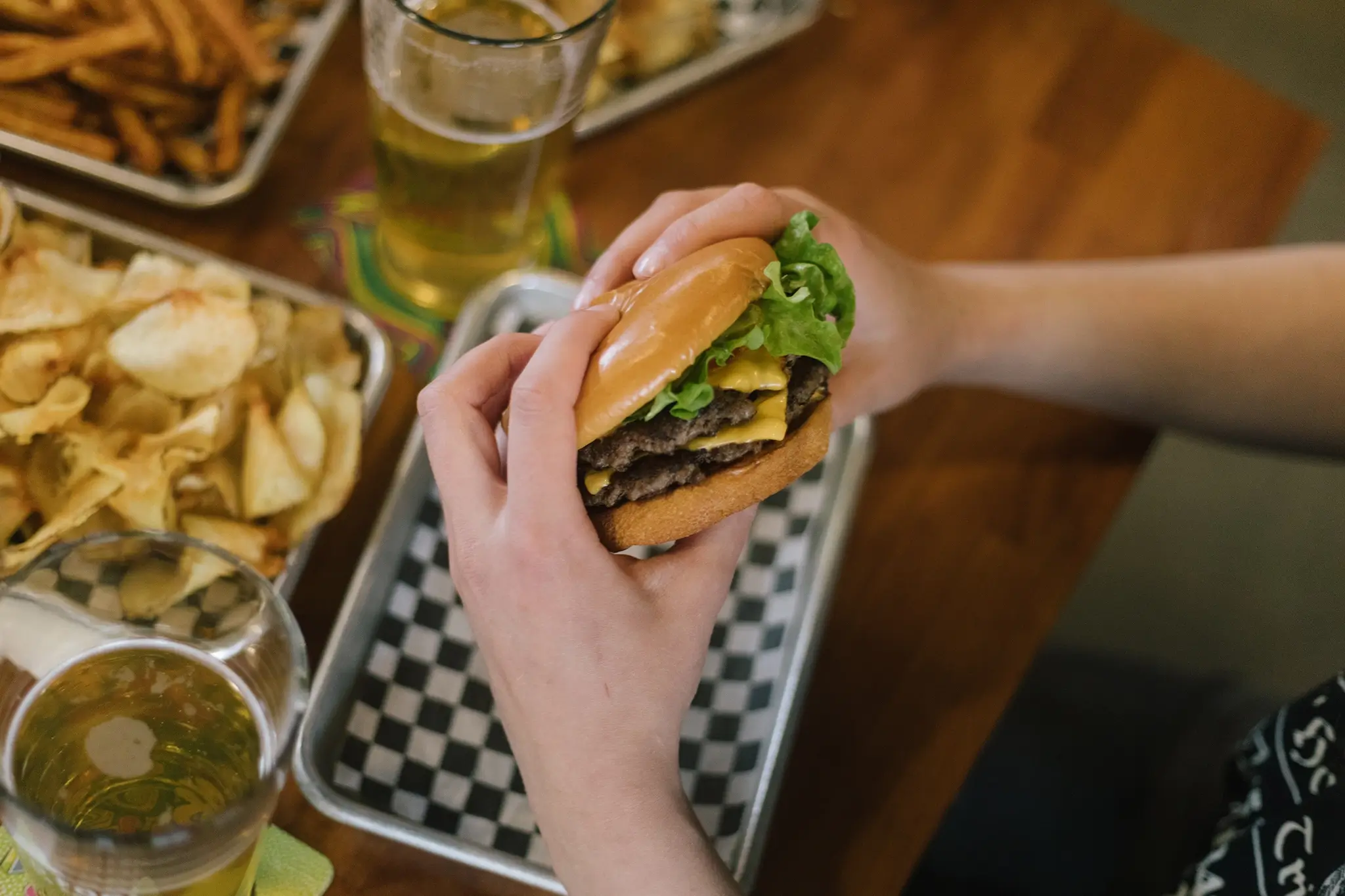 hands holding a cheeseburger